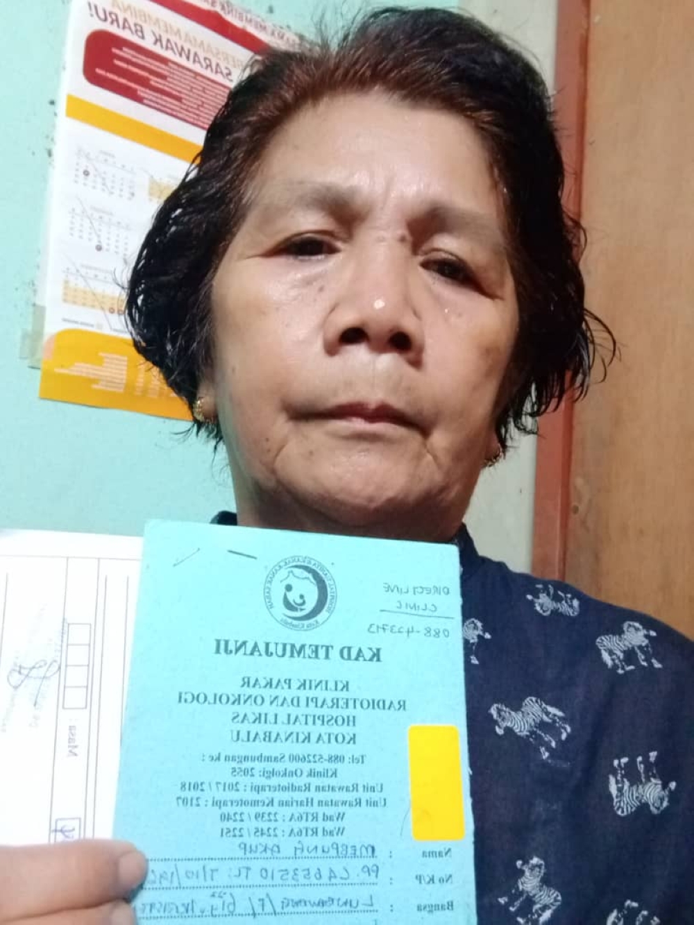 Mebpung shows her appointment card for cancer treatment. — THE LAND OF BORNEO